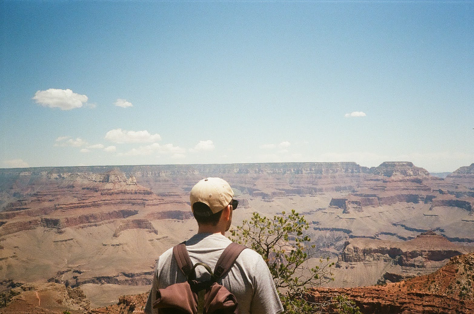 Harrison Reed looking out over the Grand Canyon from the South Rim, wearing a backpack, shot on film